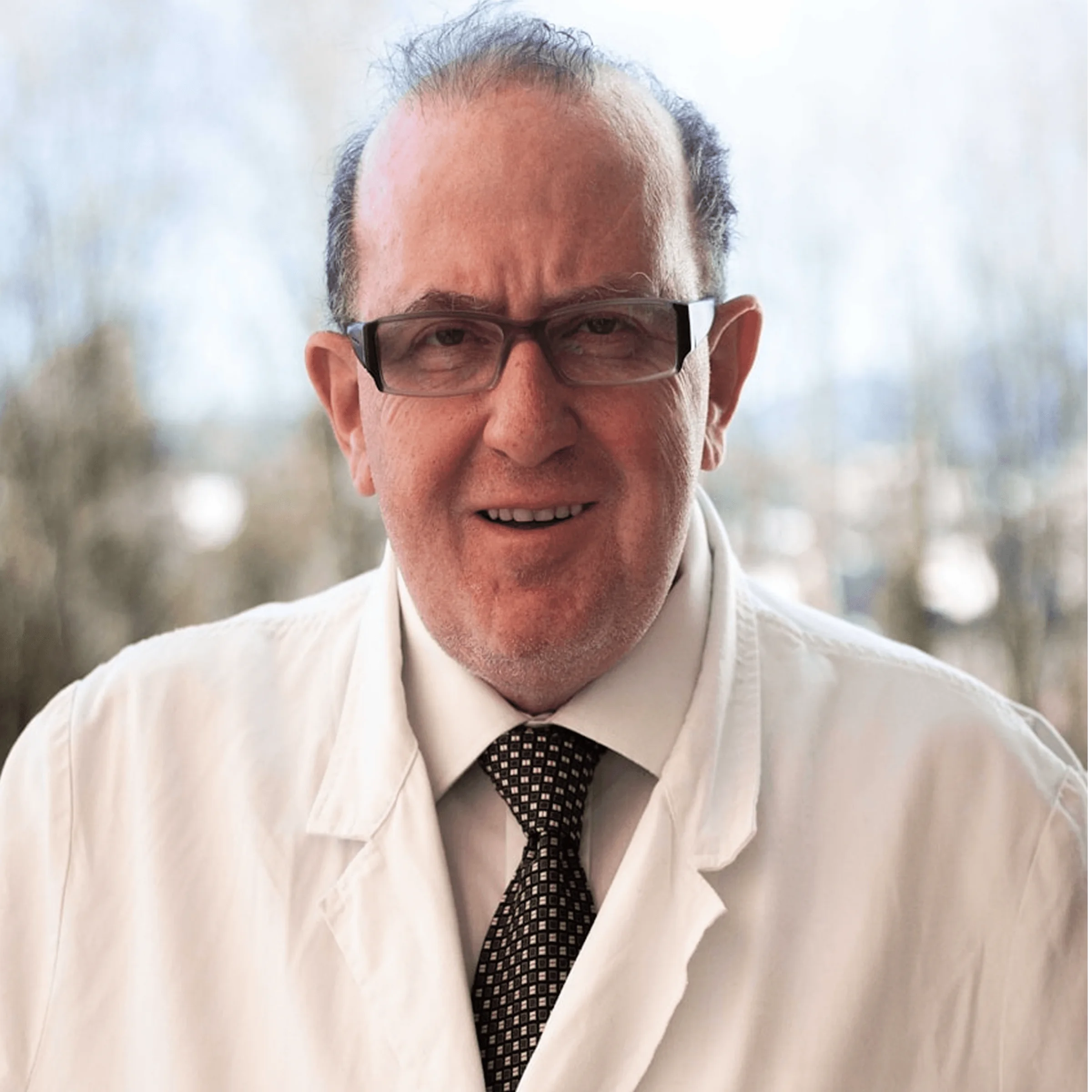 Older professional in white coat and tie standing outdoors