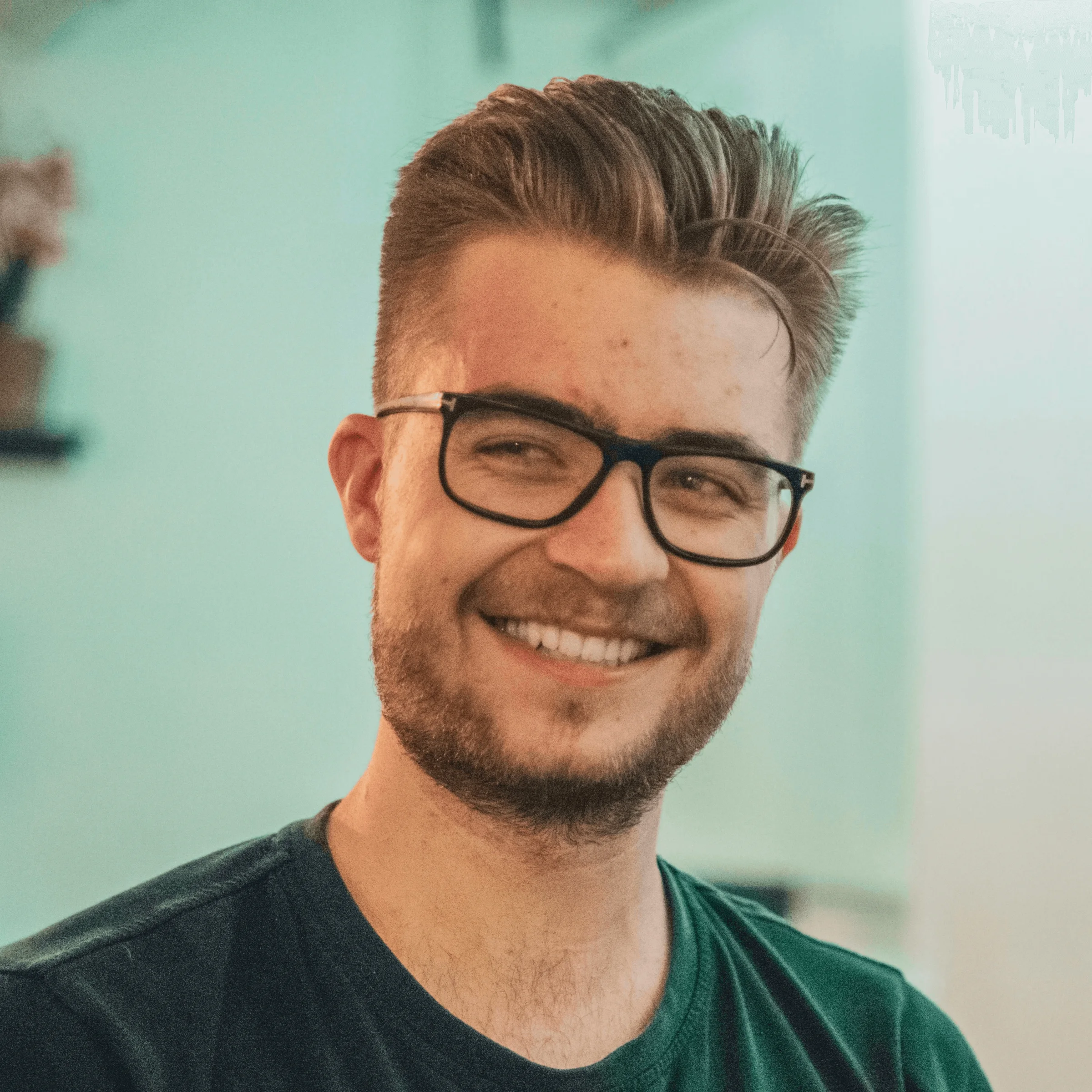 man wearing green crew-neck top and eyeglasses with black frames looking at side
