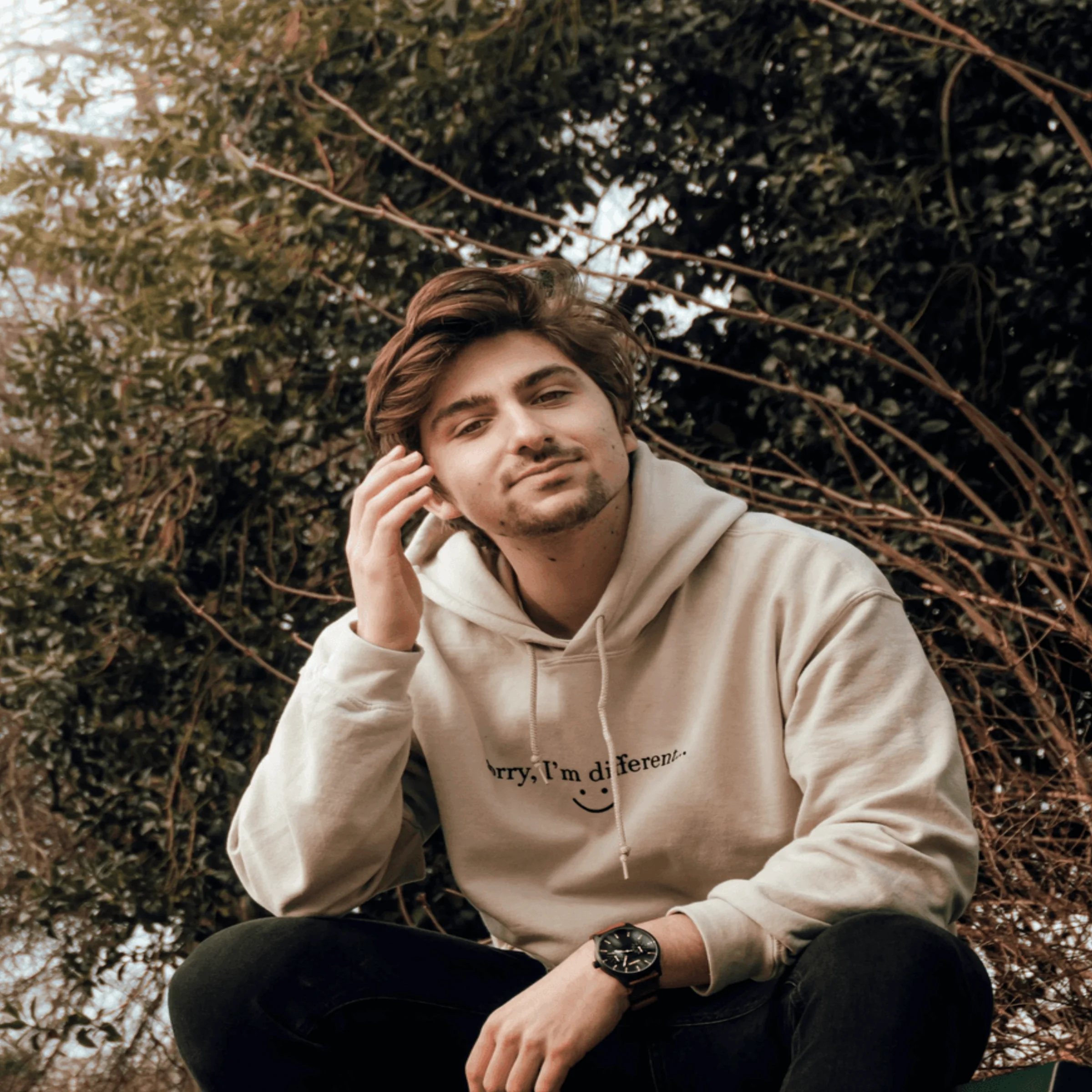 man in gray hoodie sitting on black bench
